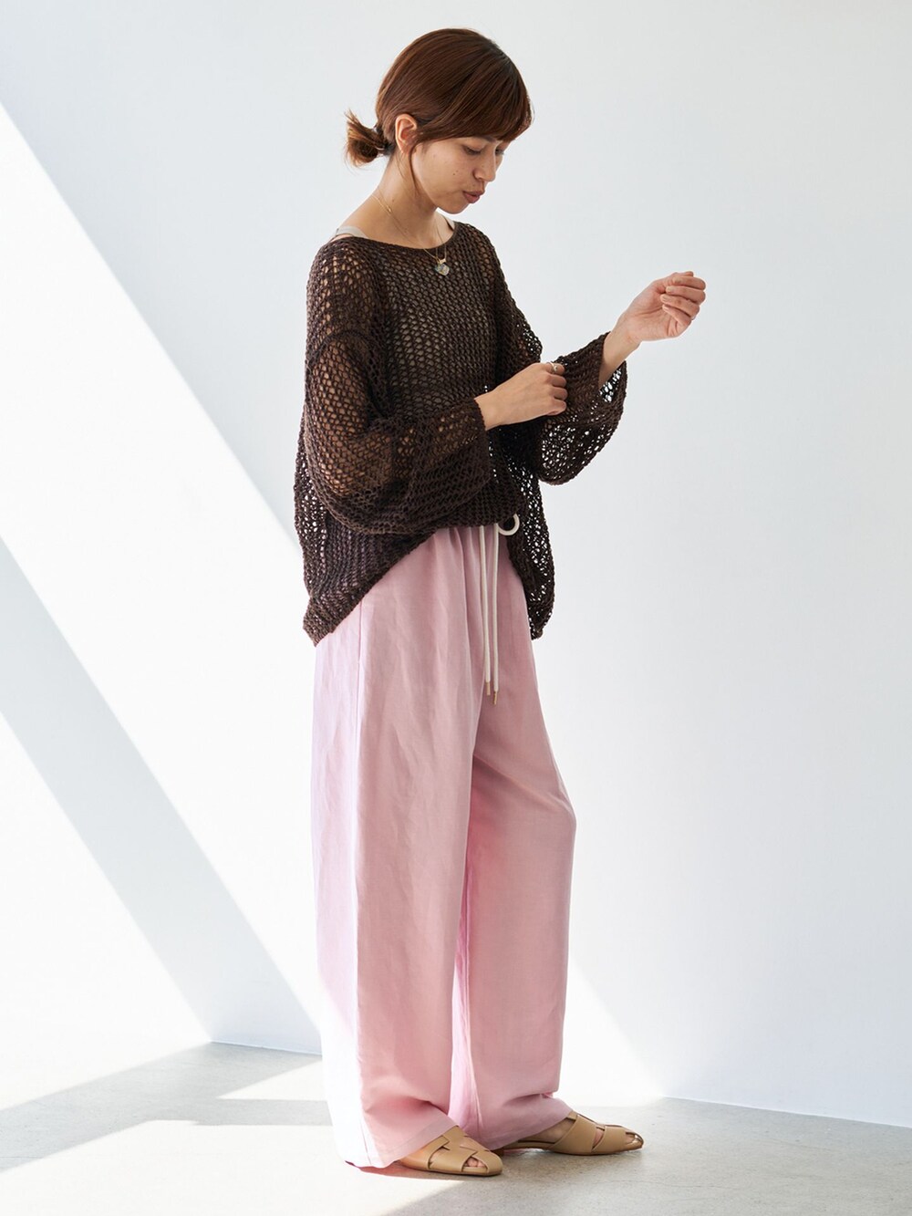 ピンク系のその他パンツ、ブラウン系のニット/セーター、ベージュ系のサンダルを着用したレディースの春コーディネートの5枚目の写真