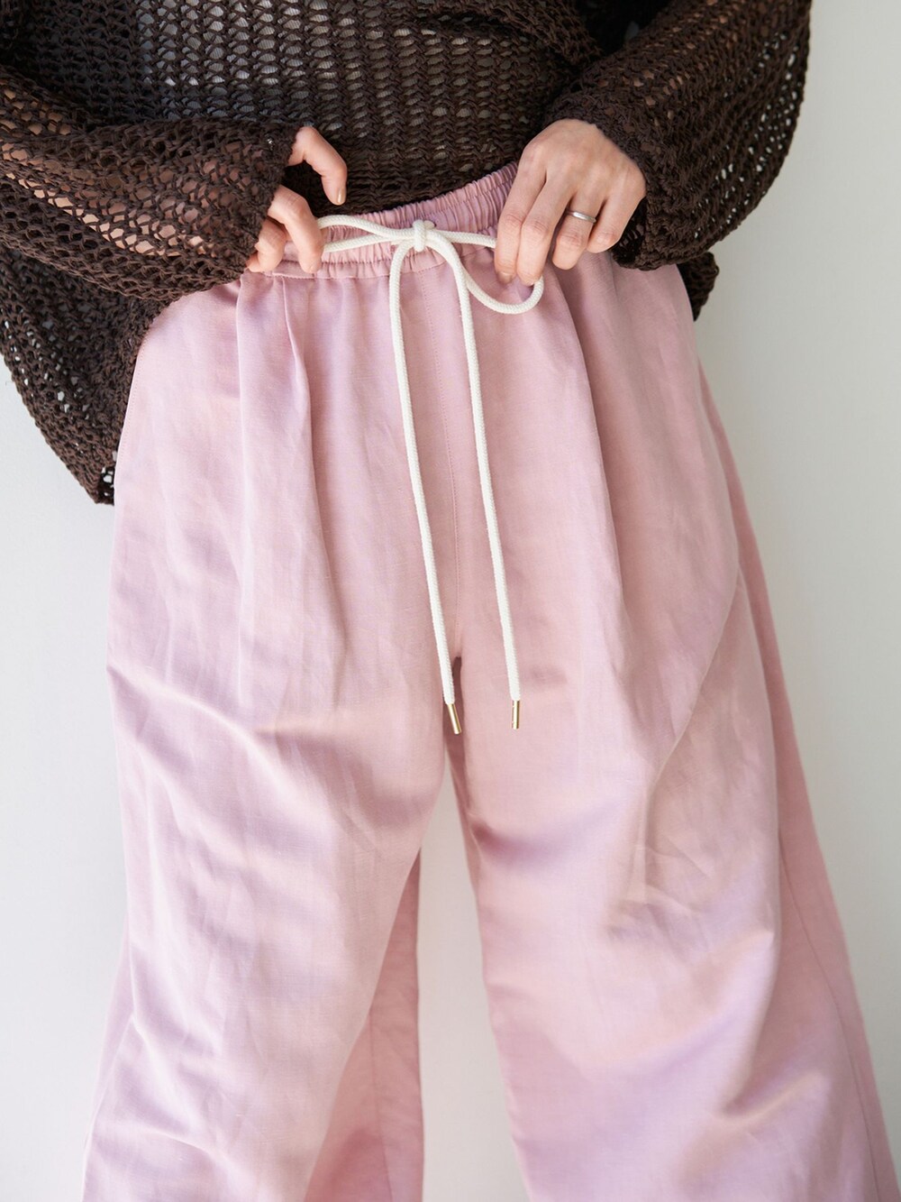 ピンク系のその他パンツ、ブラウン系のニット/セーター、ベージュ系のサンダルを着用したレディースの春コーディネートの10枚目の写真