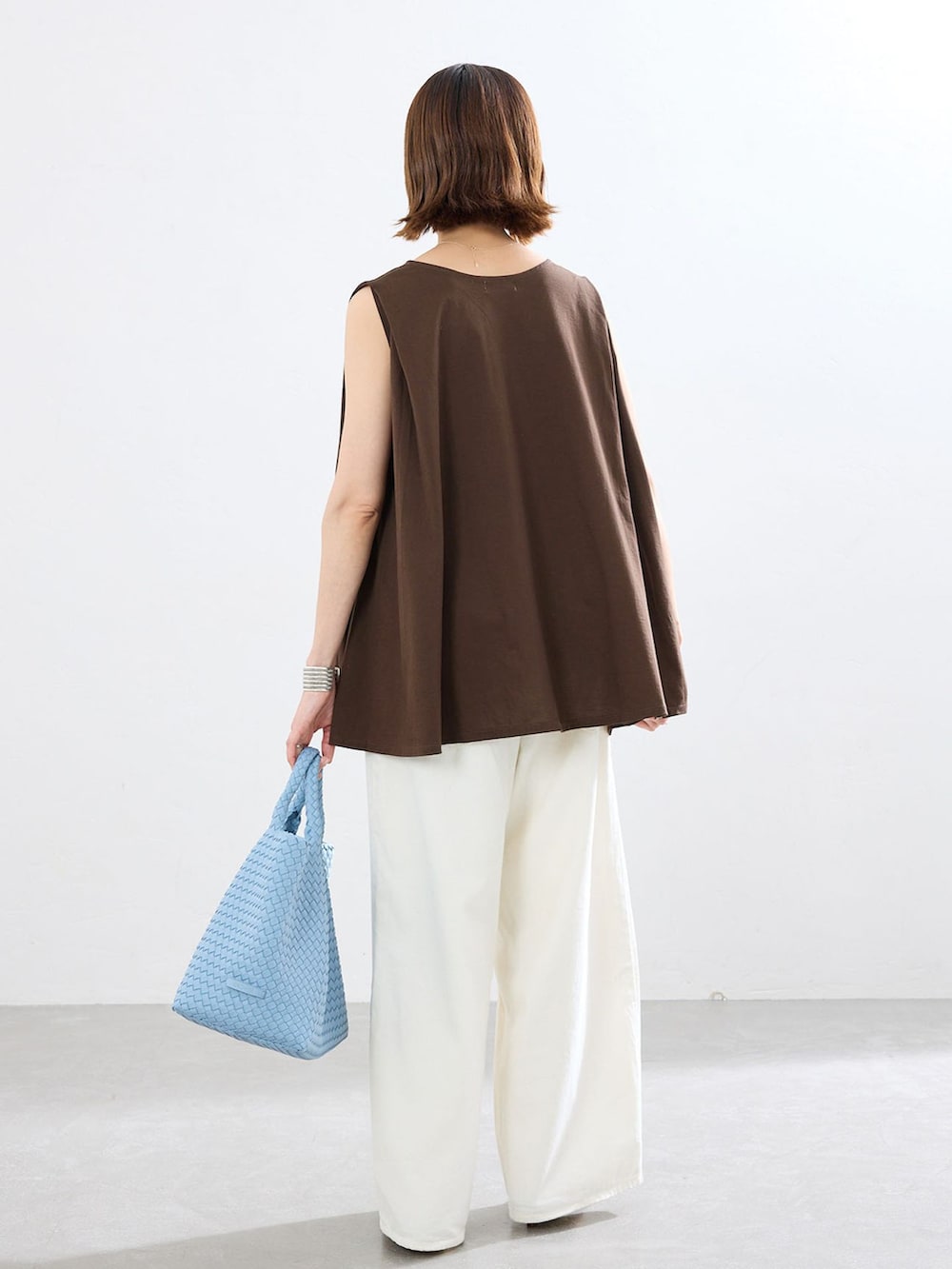 ブラウン系のTシャツ/カットソー、ブルー系のトートバッグを着用したレディースの春コーディネートの2枚目の写真