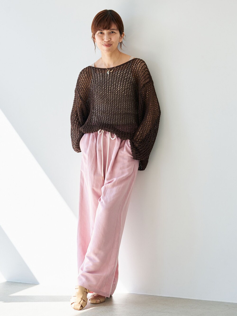ピンク系のその他パンツ、ブラウン系のニット/セーター、ベージュ系のサンダルを着用したレディースの春コーディネートの2枚目の写真