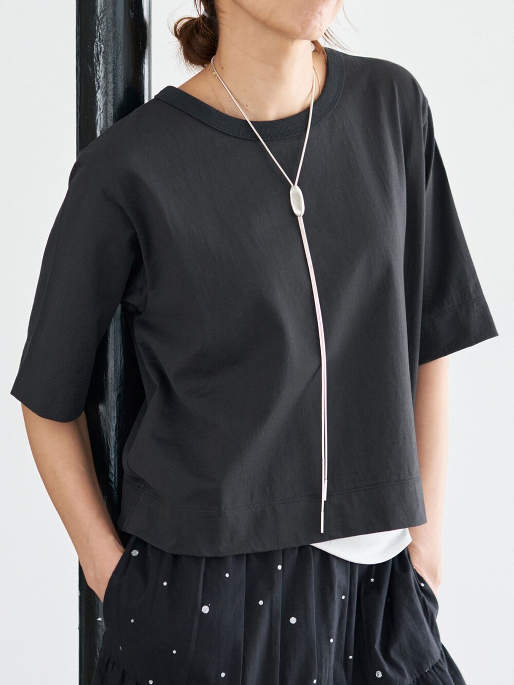 ブラック系のスカート、ブラック系のTシャツ/カットソーを着用したレディースの夏コーディネートの9枚目の写真