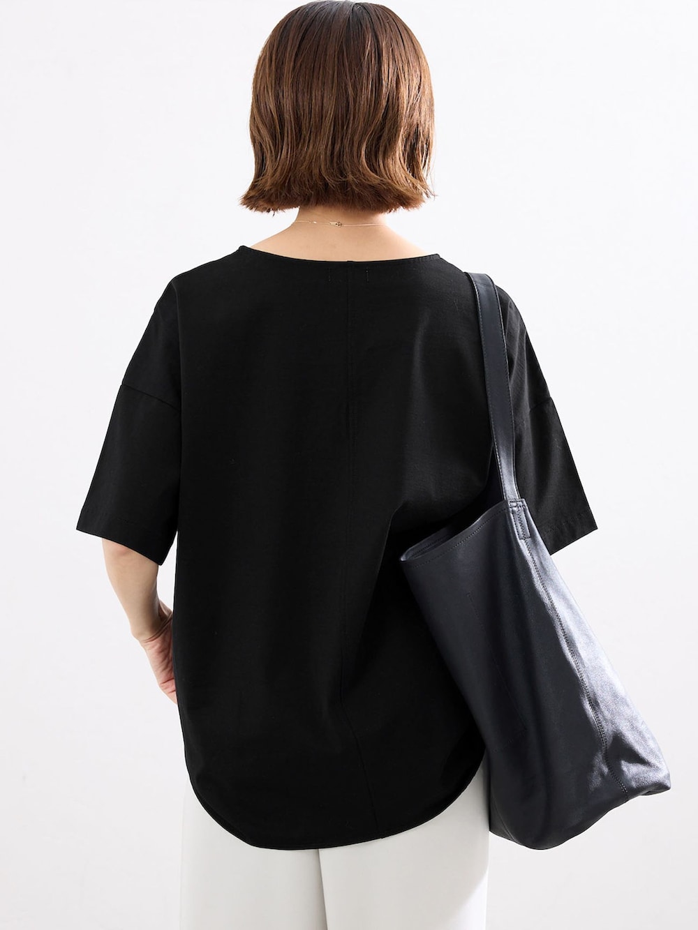 ベージュ系のその他パンツ、ブラック系のTシャツ/カットソー、ブラック系のショルダーバッグを着用したレディースの春コーディネートの5枚目の写真