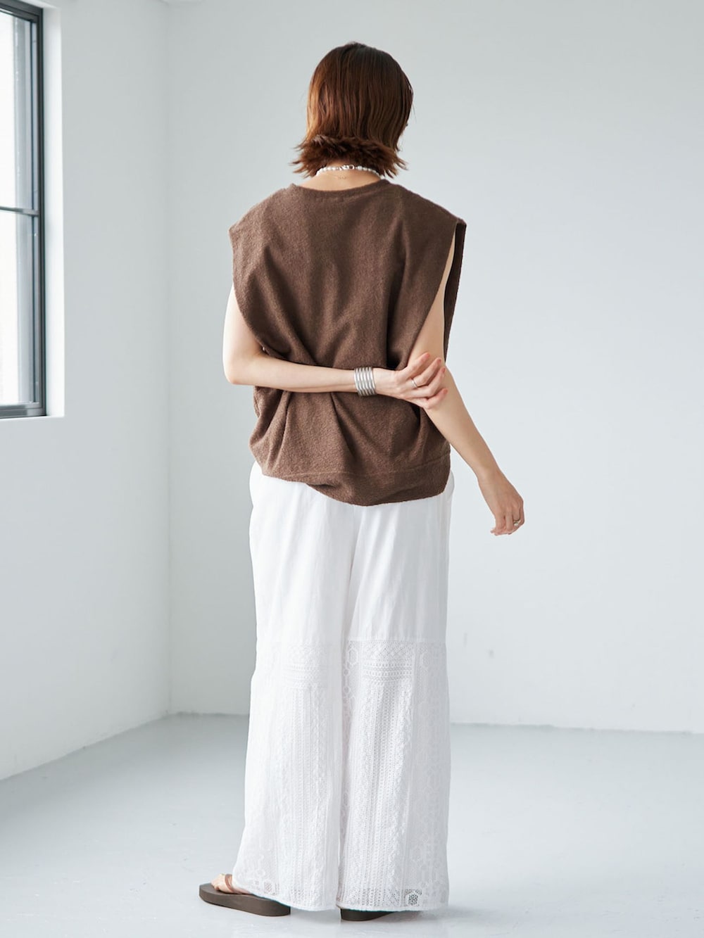 ホワイト系のその他パンツ、グリーン系のTシャツ/カットソー、ブラウン系のサンダルを着用したレディースの夏コーディネートの3枚目の写真