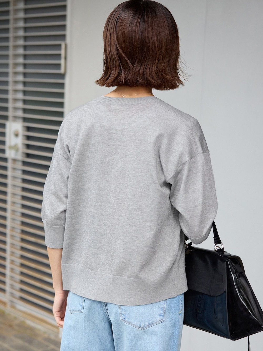 ブルー系のデニムパンツ、ホワイト系のTシャツ/カットソー、グレー系のカーディガン/ボレロを着用したレディースの春コーディネートの4枚目の写真