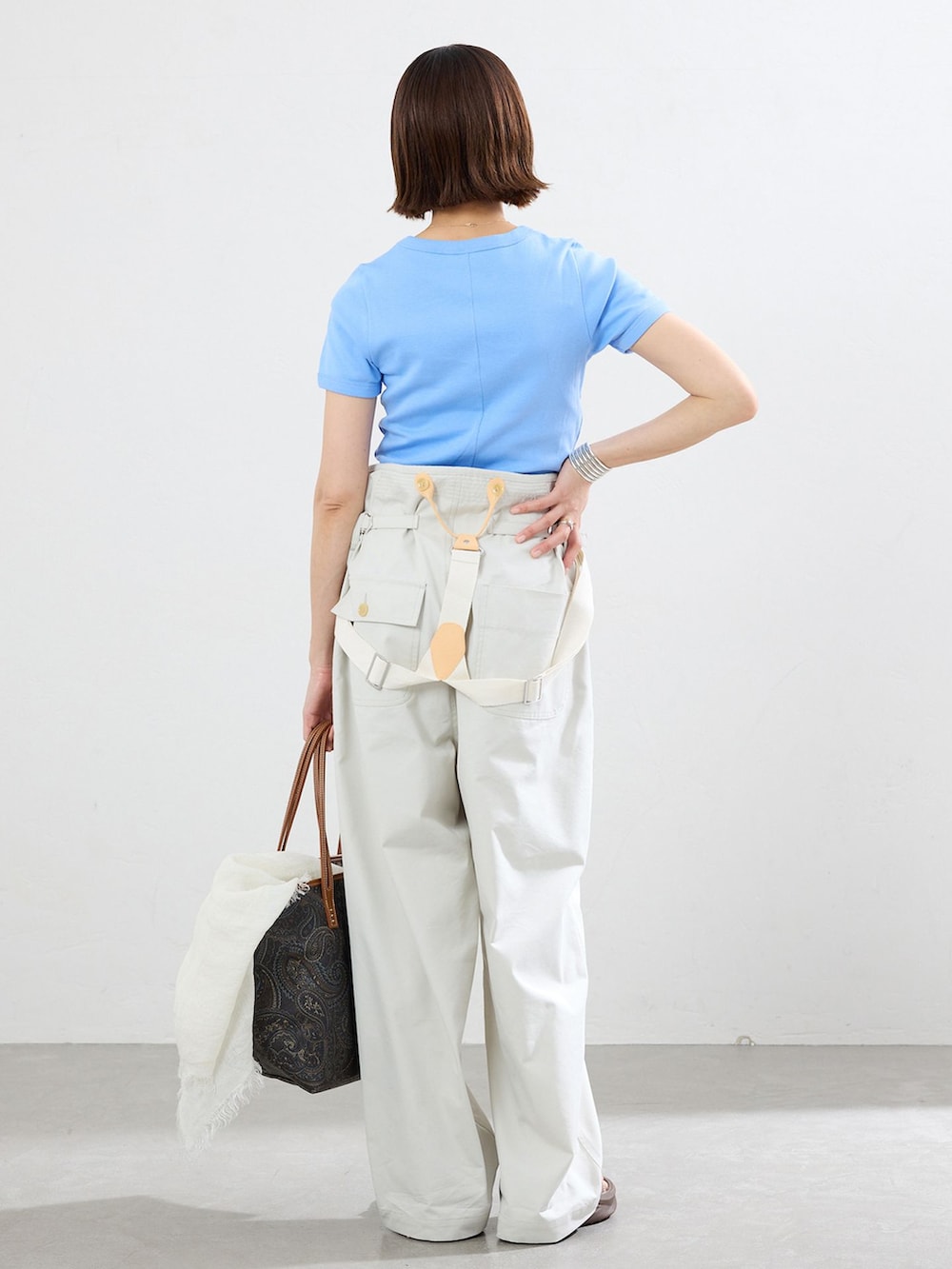 ホワイト系のその他パンツ、ブルー系のTシャツ/カットソー、ブラック系のショルダーバッグを着用したレディースの春コーディネートの2枚目の写真
