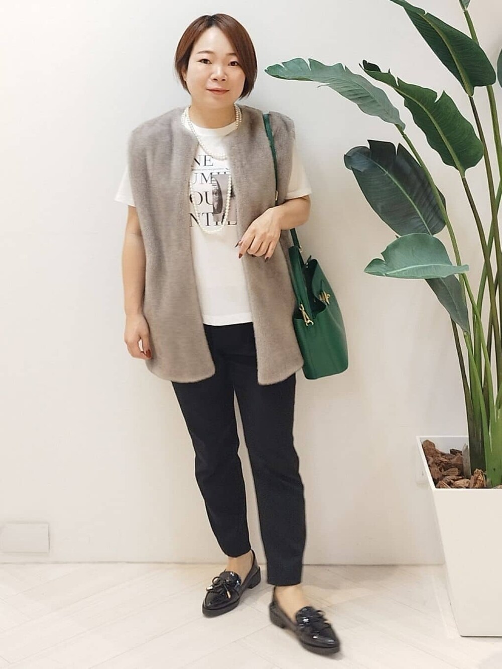 ベージュ系のベスト、ホワイト系のTシャツ/カットソー、ブラック系のその他パンツを着用したレディースの秋コーディネートの3枚目の写真