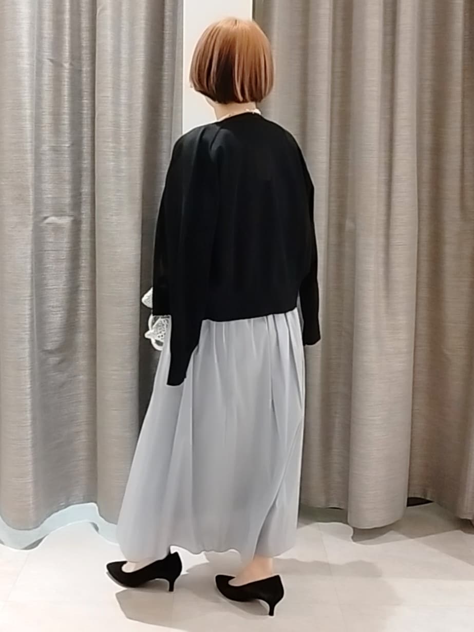 ブルー系のスカート、ブラック系のカーディガン/ボレロ、シルバー系のトートバッグを着用したレディースの春コーディネートの7枚目の写真