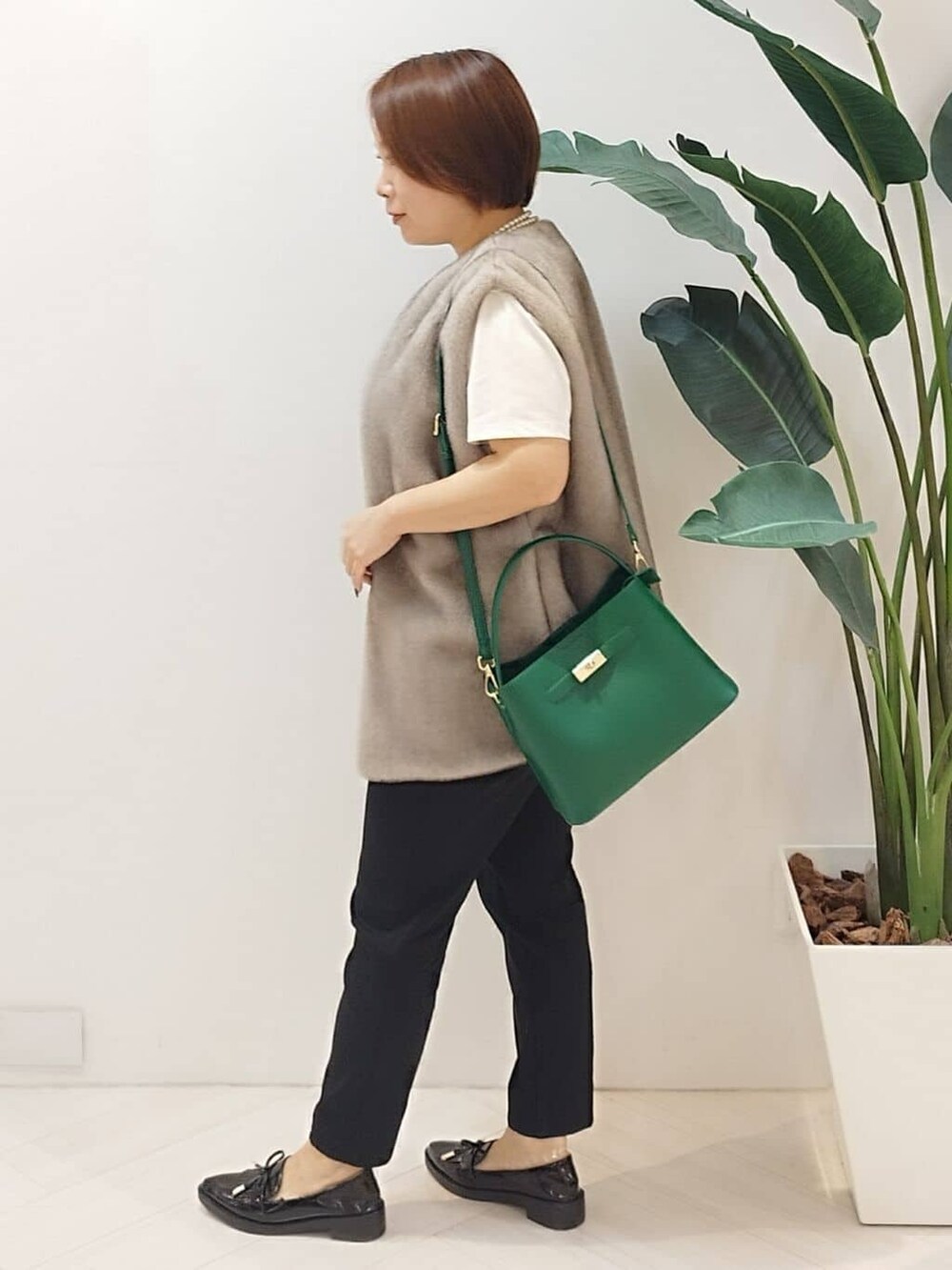 ベージュ系のベスト、ホワイト系のTシャツ/カットソー、ブラック系のその他パンツを着用したレディースの秋コーディネートの5枚目の写真