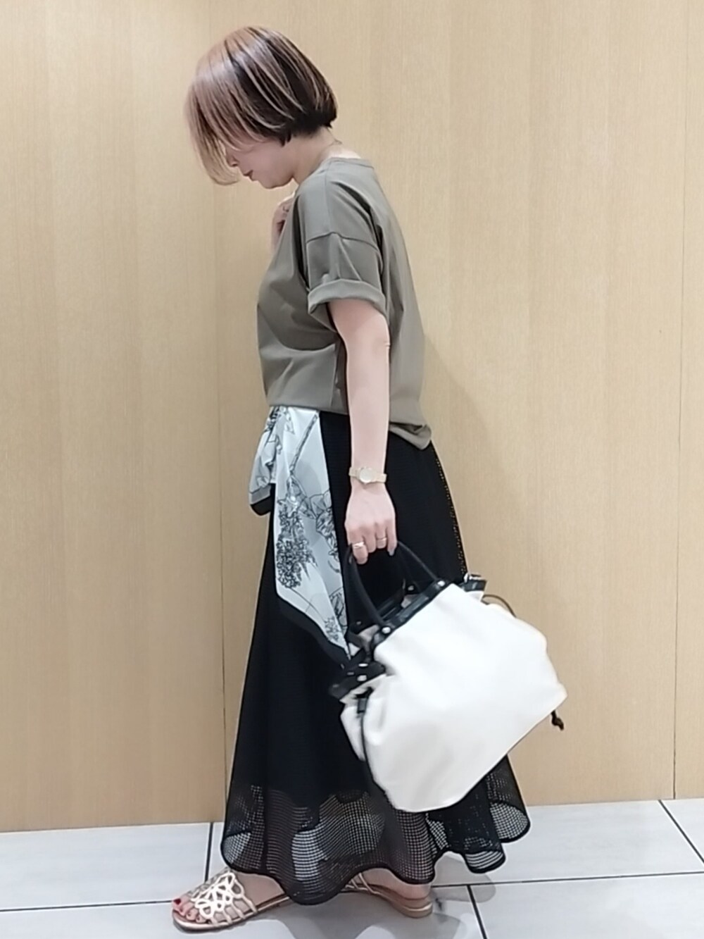 グリーン系のTシャツ/カットソー、ブラック系のスカートを着用したレディースの春コーディネートの3枚目の写真