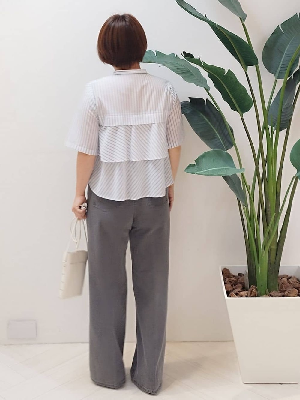 ホワイト系のシャツ/ブラウス、グレー系のデニムパンツを着用したレディースの秋コーディネートの8枚目の写真