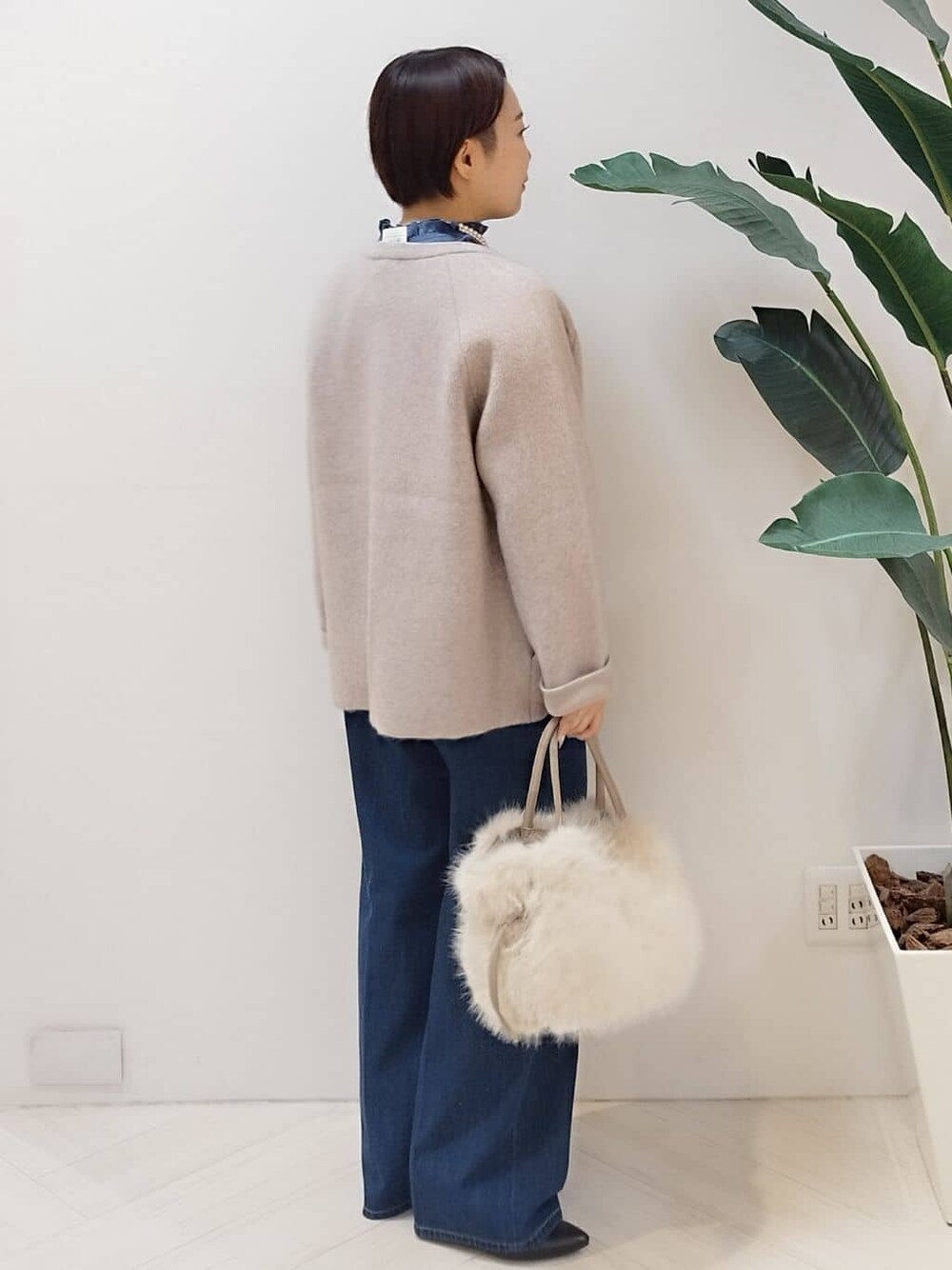 ベージュ系のカーディガン/ボレロ、ブルー系のシャツ/ブラウス、ブルー系のデニムパンツを着用したレディースの冬コーディネートの3枚目の写真