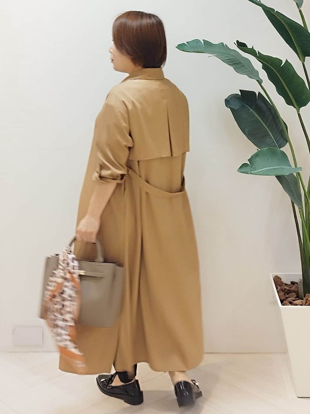 イエロー系のワンピース、ホワイト系のTシャツ/カットソー、ブラック系のその他パンツを着用したレディースの秋コーディネートの7枚目の写真