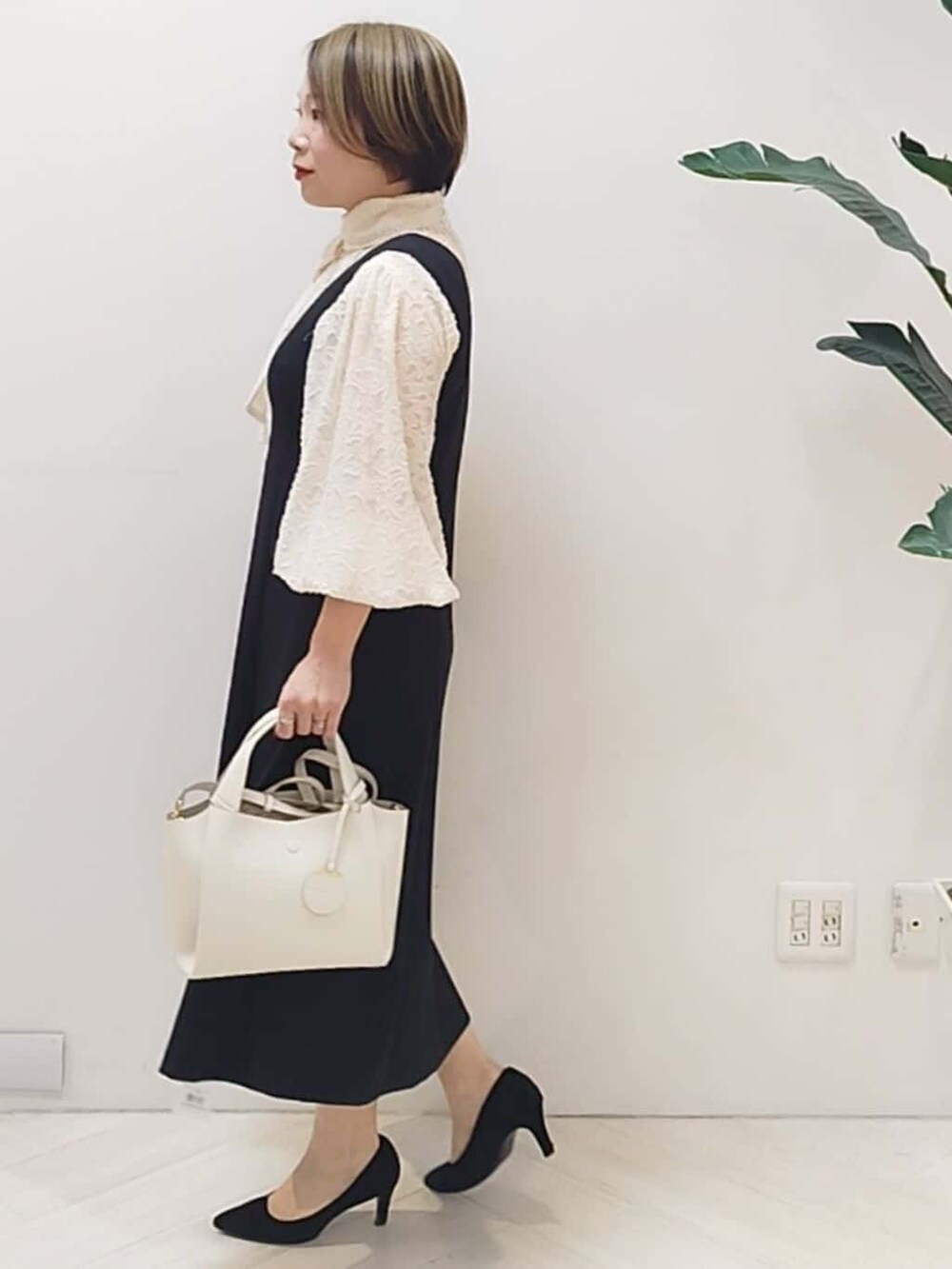 ブラック系のワンピース、ホワイト系のシャツ/ブラウス、ホワイト系のショルダーバッグを着用したレディースの冬コーディネートの4枚目の写真