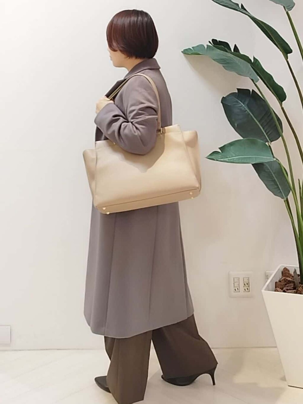 グレー系のチェスターコート、ベージュ系のシャツ/ブラウス、ブラウン系のその他パンツを着用したレディースの冬コーディネートの3枚目の写真