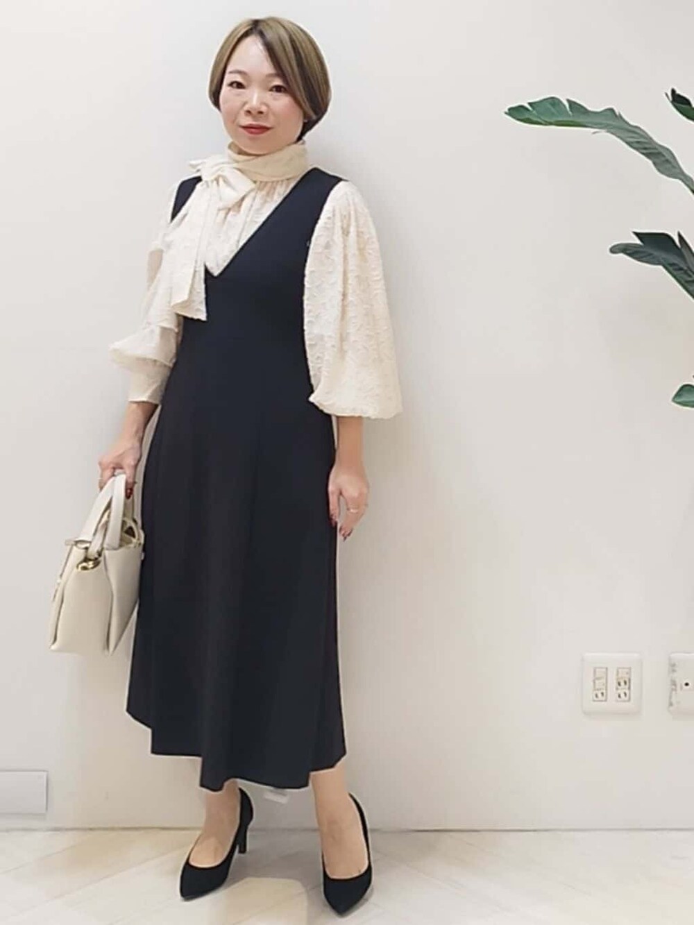 ブラック系のワンピース、ホワイト系のシャツ/ブラウス、ホワイト系のショルダーバッグを着用したレディースの冬コーディネートの3枚目の写真