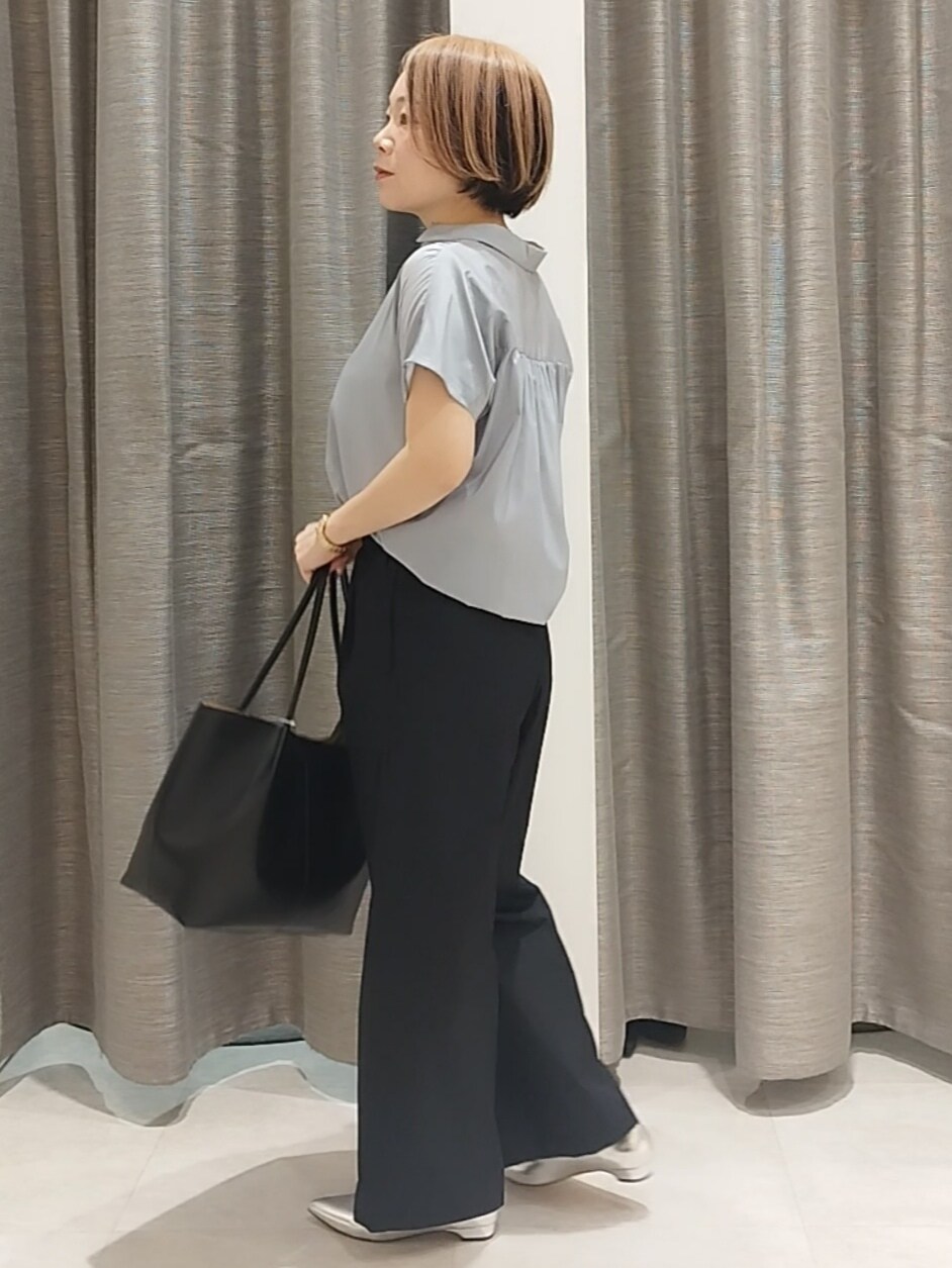 シルバー系のその他シューズ、ブルー系のシャツ/ブラウス、ブラック系のトートバッグを着用したレディースの春コーディネートの8枚目の写真