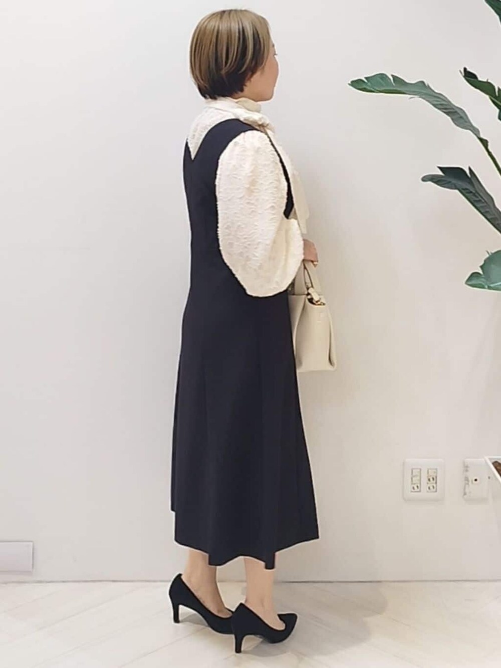 ブラック系のワンピース、ホワイト系のシャツ/ブラウス、ホワイト系のショルダーバッグを着用したレディースの冬コーディネートの7枚目の写真