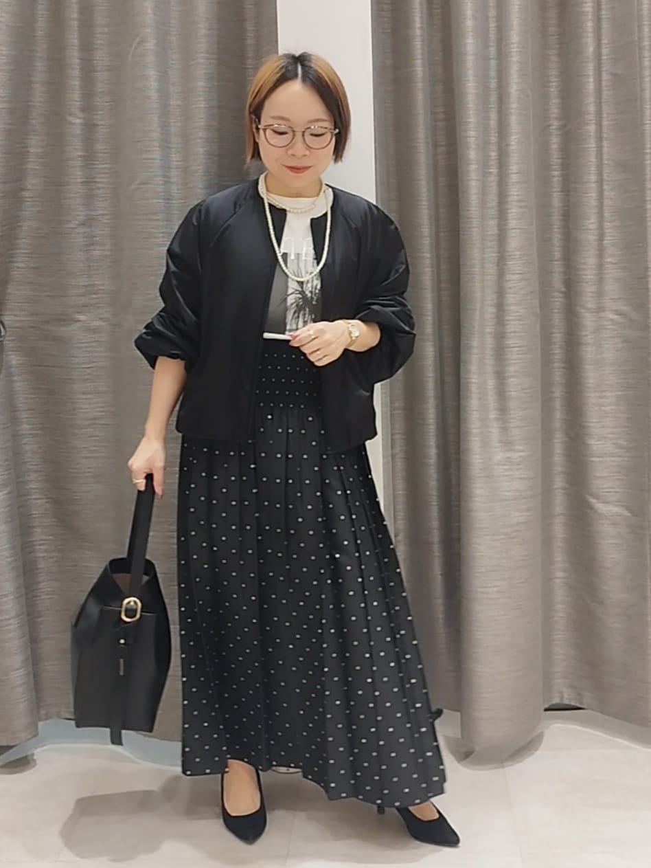 ホワイト系のTシャツ/カットソー、ブラック系のスカート、ブラック系のショルダーバッグを着用したレディースの秋コーディネートの2枚目の写真