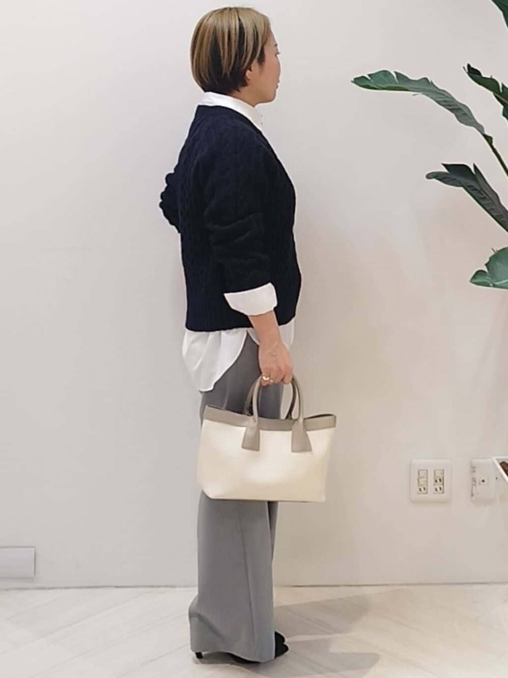ブルー系のニット/セーター、ホワイト系のシャツ/ブラウス、グレー系のその他パンツを着用したレディースの冬コーディネートの5枚目の写真