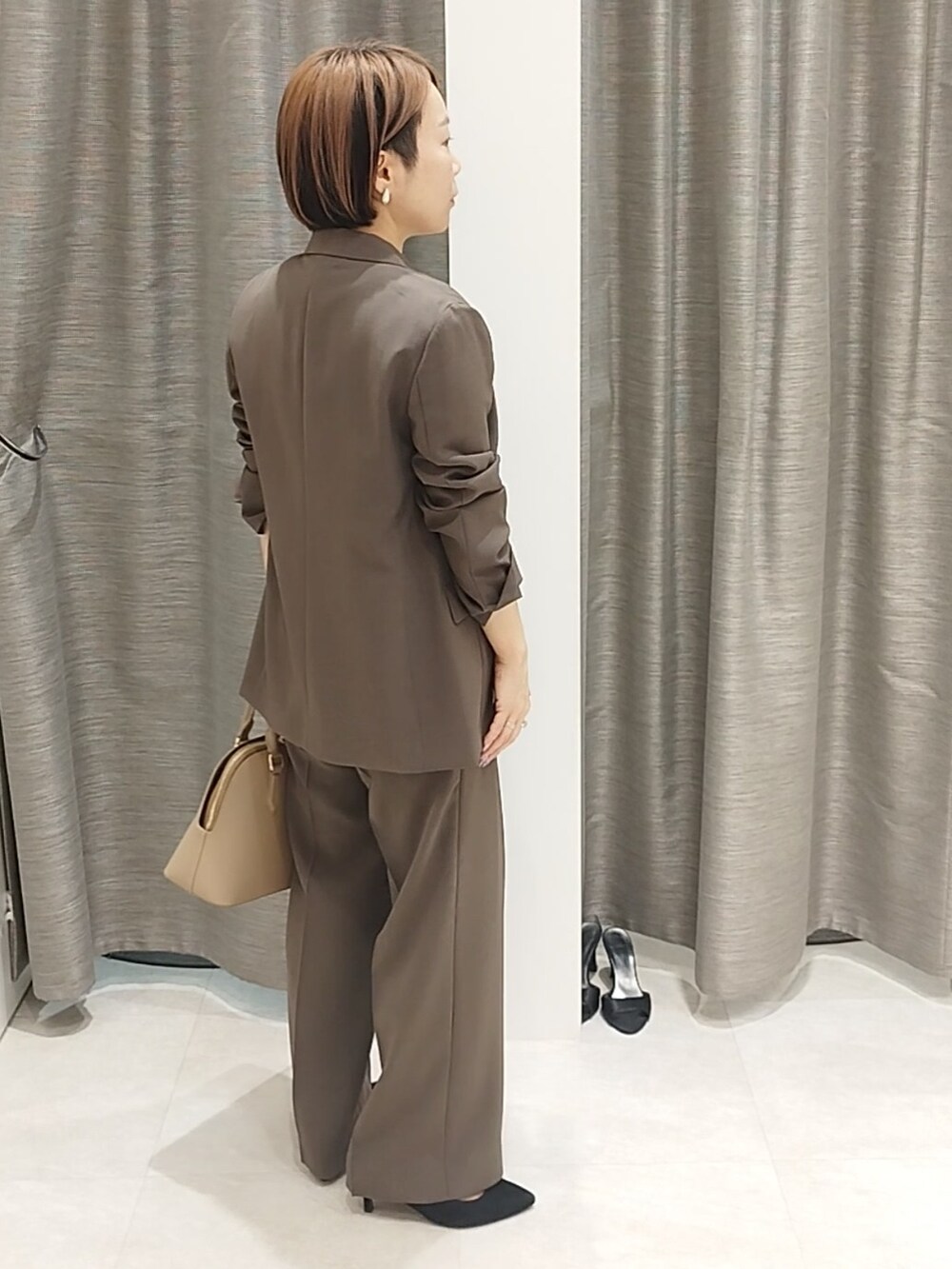 ホワイト系のシャツ/ブラウス、ブラウン系のハンドバッグ、ブラウン系のその他パンツを着用したレディースの春コーディネートの3枚目の写真