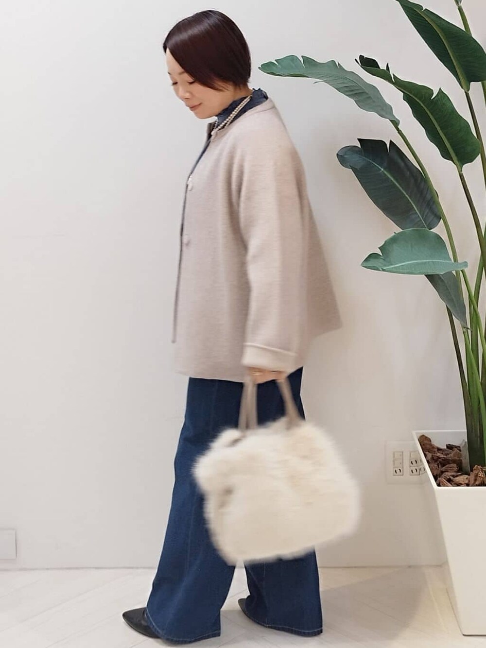 ベージュ系のカーディガン/ボレロ、ブルー系のシャツ/ブラウス、ブルー系のデニムパンツを着用したレディースの冬コーディネートの5枚目の写真