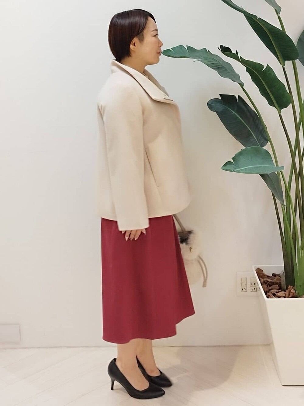 ベージュ系のその他アウター、ベージュ系のニット/セーター、レッド系のスカートを着用したレディースの冬コーディネートの3枚目の写真