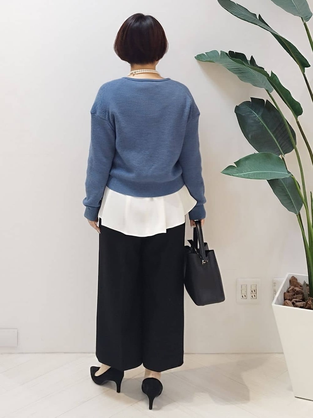ブルー系のカーディガン/ボレロ、ホワイト系のシャツ/ブラウス、ブラック系のその他パンツを着用したレディースの冬コーディネートの6枚目の写真