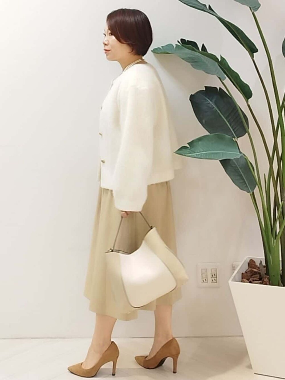 ホワイト系のカーディガン/ボレロ、ベージュ系のワンピース、ベージュ系のショルダーバッグを着用したレディースの秋コーディネートの5枚目の写真