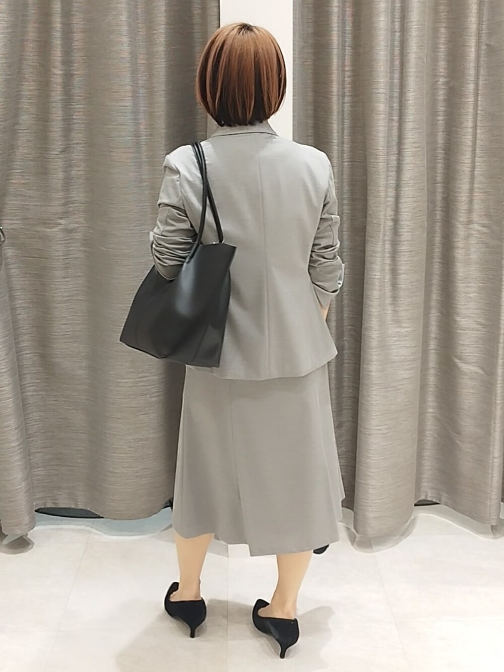 グレー系のテーラードジャケット、グレー系のスカート、ホワイト系のシャツ/ブラウスを着用したレディースの春コーディネートの8枚目の写真
