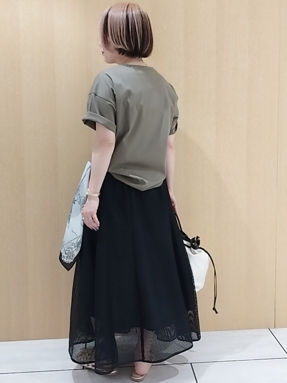 グリーン系のTシャツ/カットソー、ブラック系のスカートを着用したレディースの春コーディネートの4枚目の写真