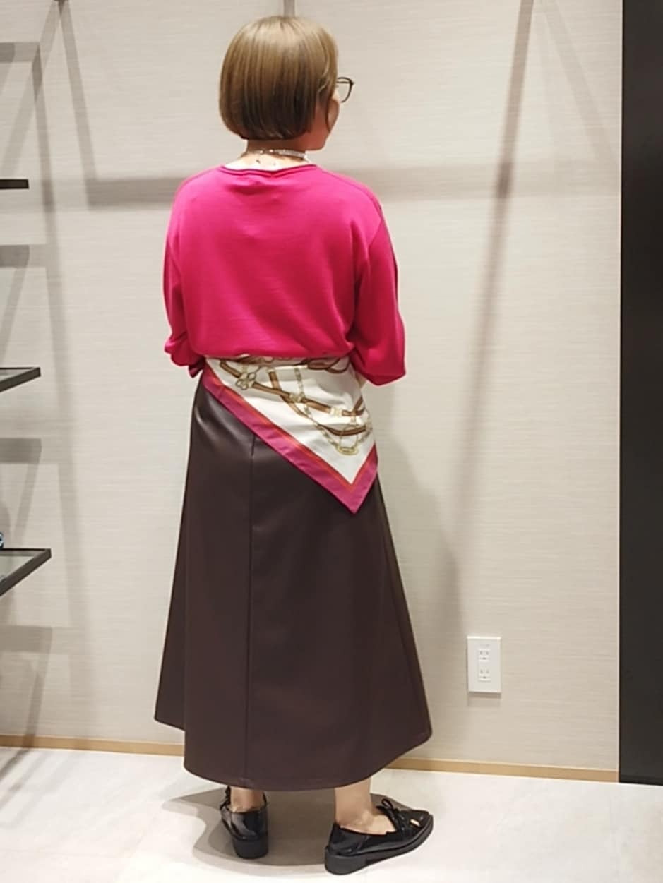 ピンク系のニット/セーター、ブラウン系のハンドバッグ、シルバー系のネックレスを着用したレディースの秋コーディネートの6枚目の写真