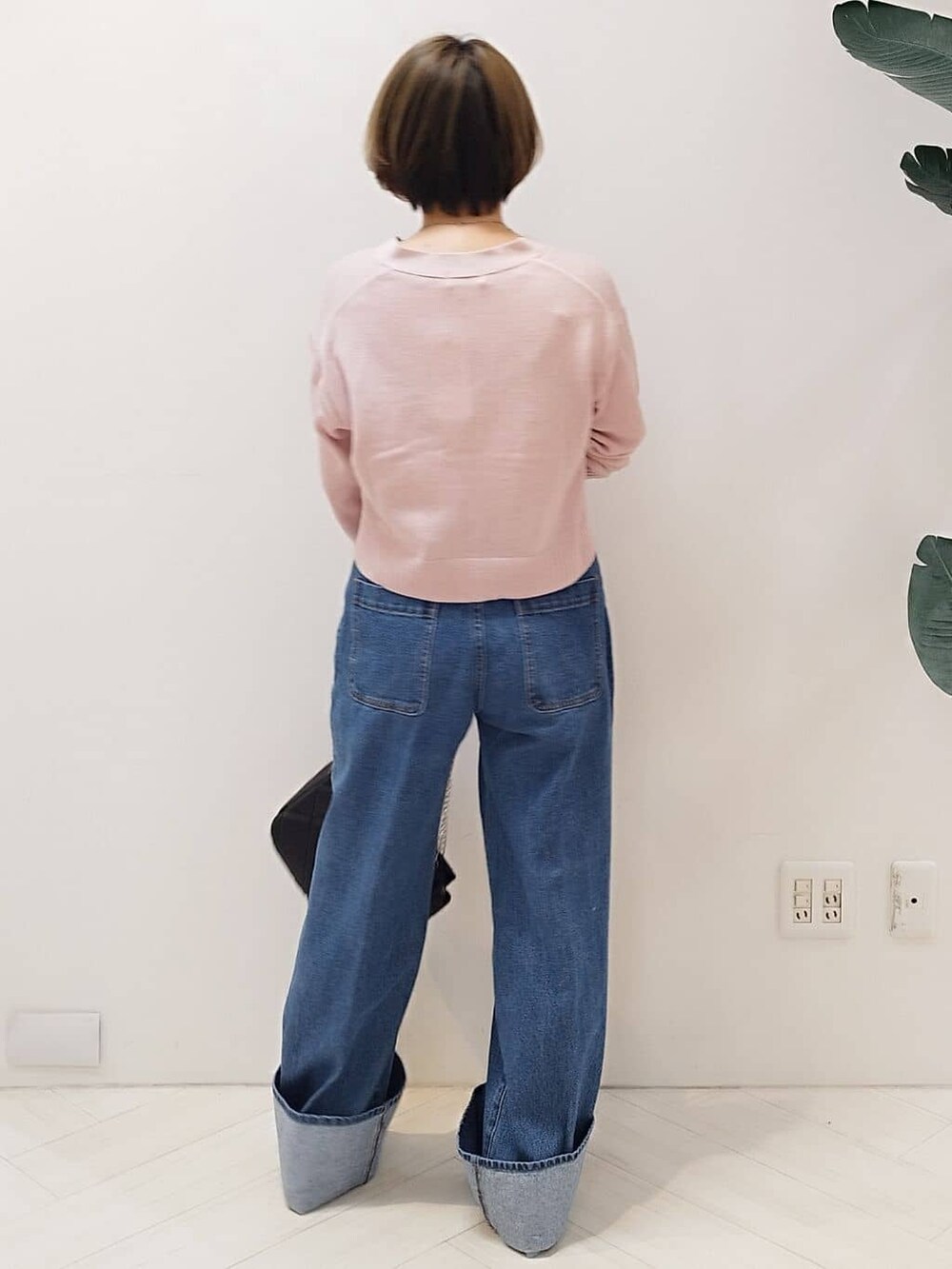 ピンク系のカーディガン/ボレロ、ブルー系のデニムパンツ、ブラック系のショルダーバッグを着用したレディースの冬コーディネートの4枚目の写真