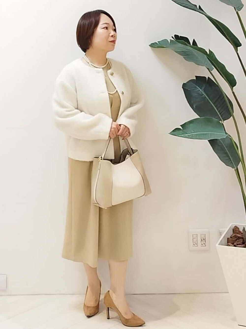 ホワイト系のカーディガン/ボレロ、ベージュ系のワンピース、ベージュ系のショルダーバッグを着用したレディースの秋コーディネートの2枚目の写真