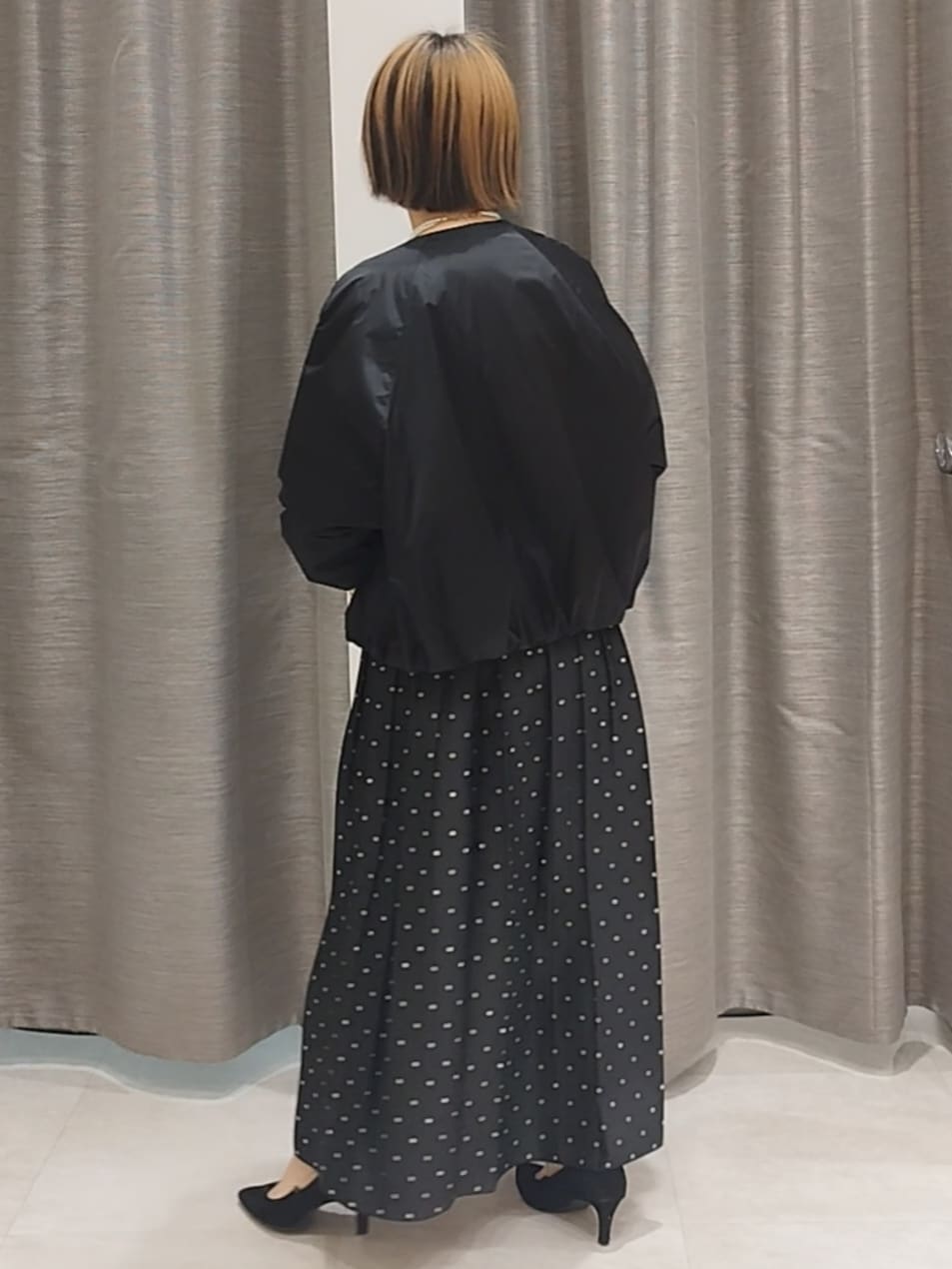 ホワイト系のTシャツ/カットソー、ブラック系のスカート、ブラック系のショルダーバッグを着用したレディースの秋コーディネートの6枚目の写真