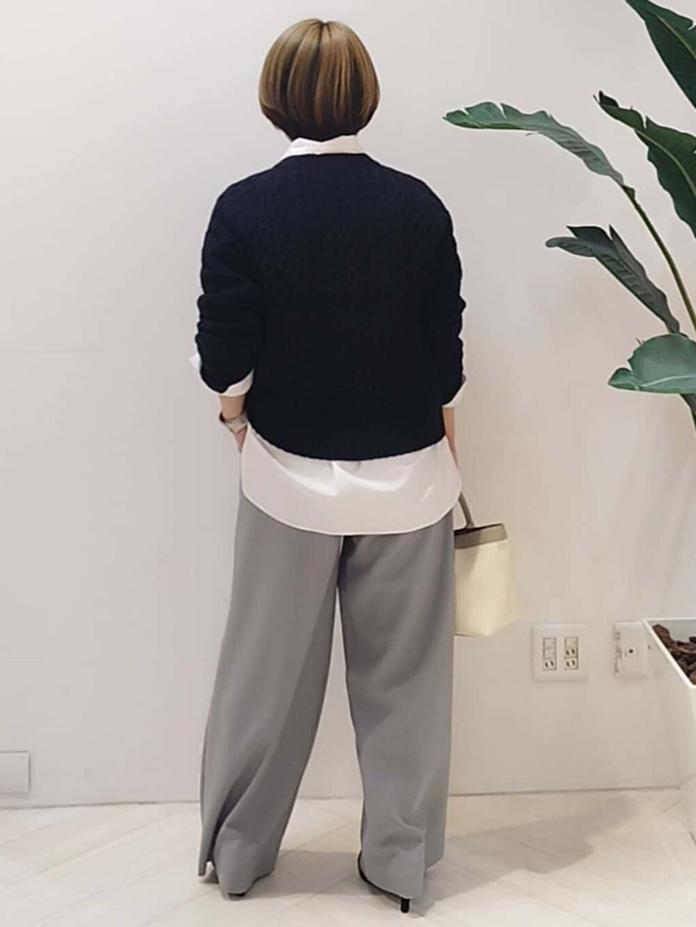 ブルー系のニット/セーター、ホワイト系のシャツ/ブラウス、グレー系のその他パンツを着用したレディースの冬コーディネートの7枚目の写真