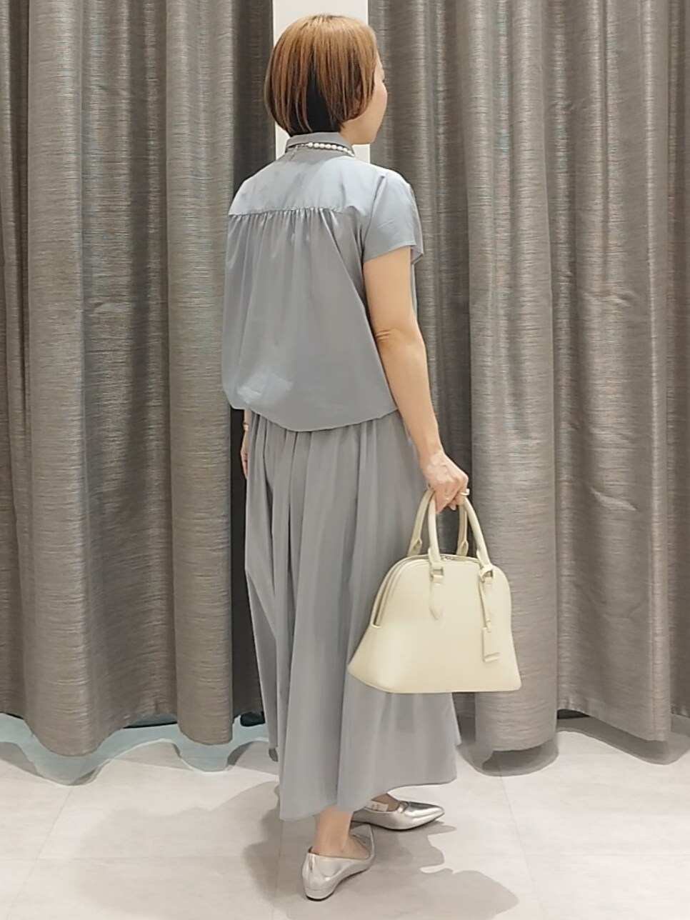 ブラック系のシャツ/ブラウス、ベージュ系のハンドバッグ、ベージュ系のトートバッグを着用したレディースの春コーディネートの7枚目の写真