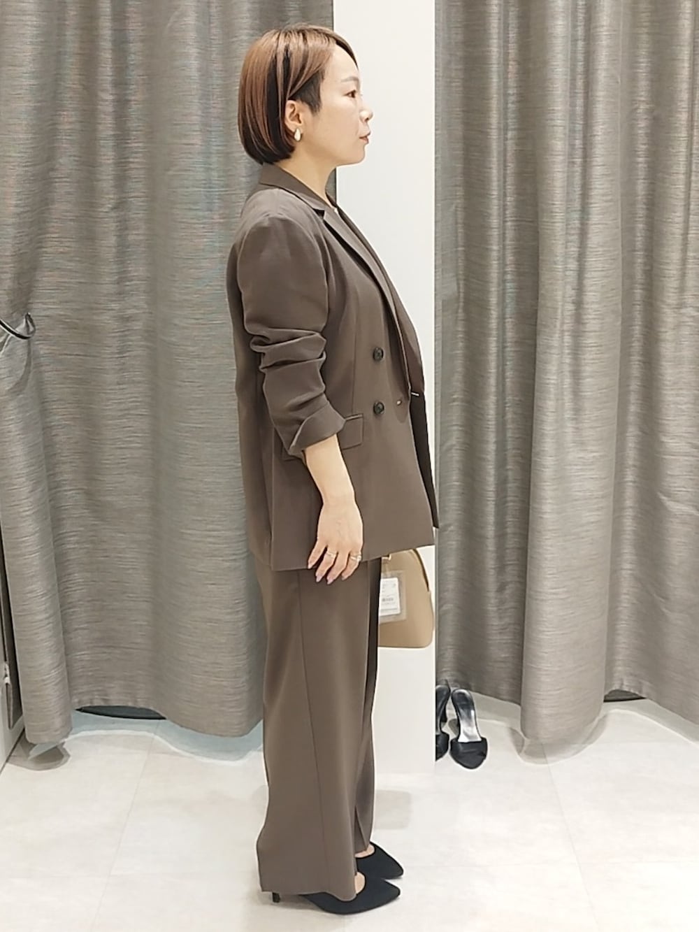ホワイト系のシャツ/ブラウス、ブラウン系のハンドバッグ、ブラウン系のその他パンツを着用したレディースの春コーディネートの2枚目の写真
