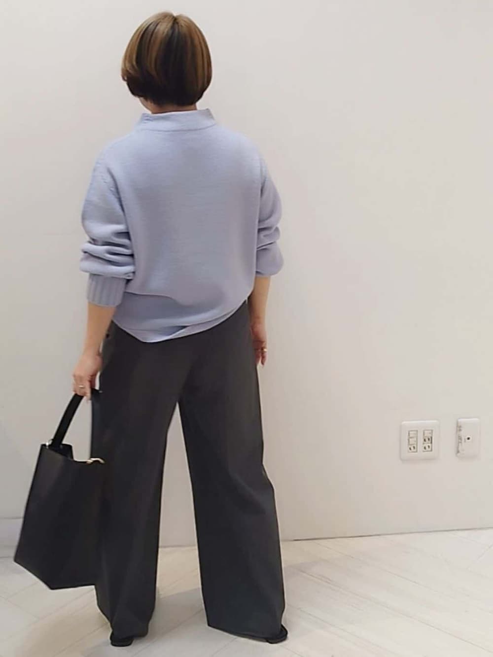 パープル系のニット/セーター、グレー系のその他パンツ、ブラック系のトートバッグを着用したレディースの冬コーディネートの6枚目の写真
