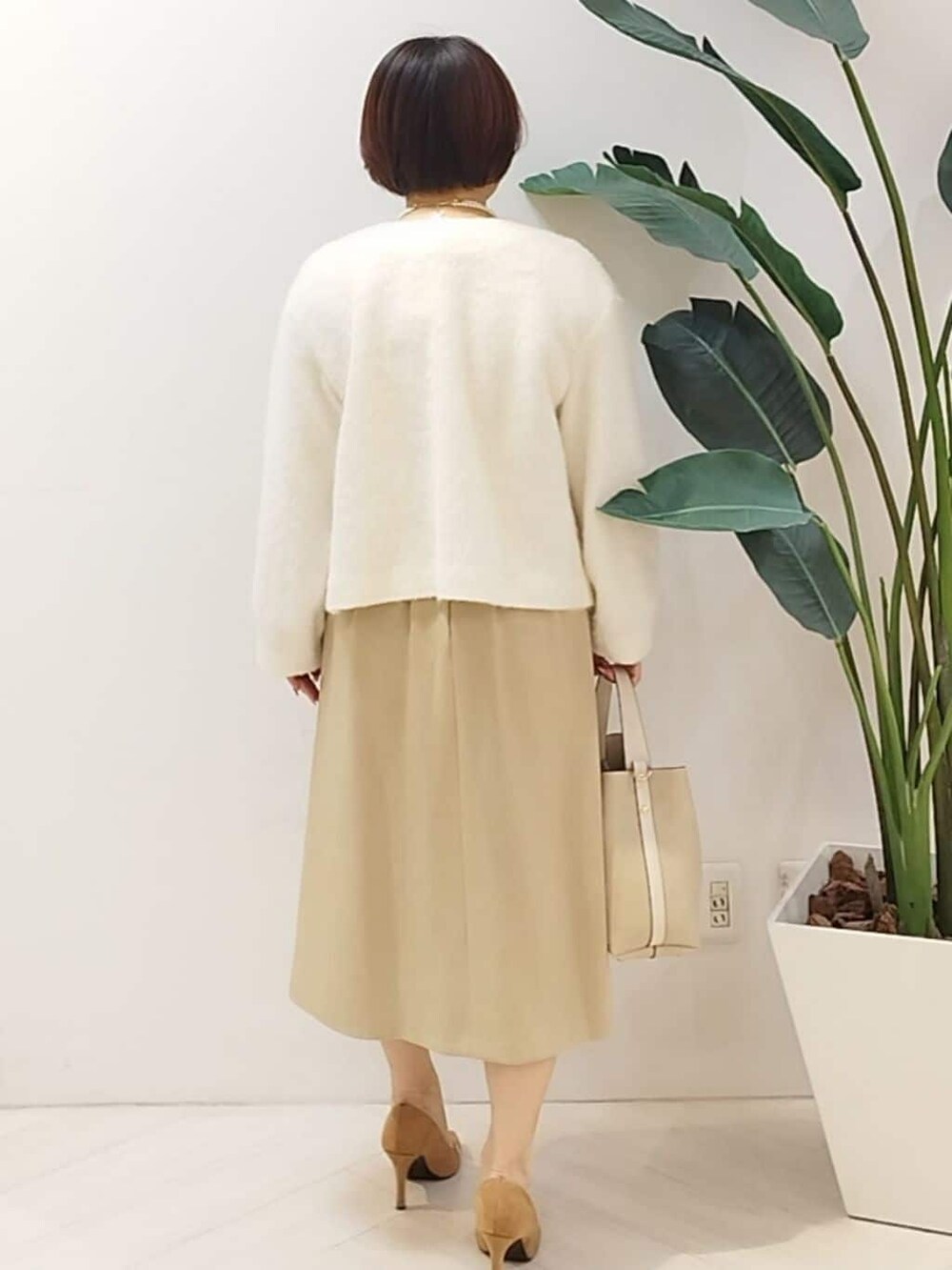 ホワイト系のカーディガン/ボレロ、ベージュ系のワンピース、ベージュ系のショルダーバッグを着用したレディースの秋コーディネートの8枚目の写真