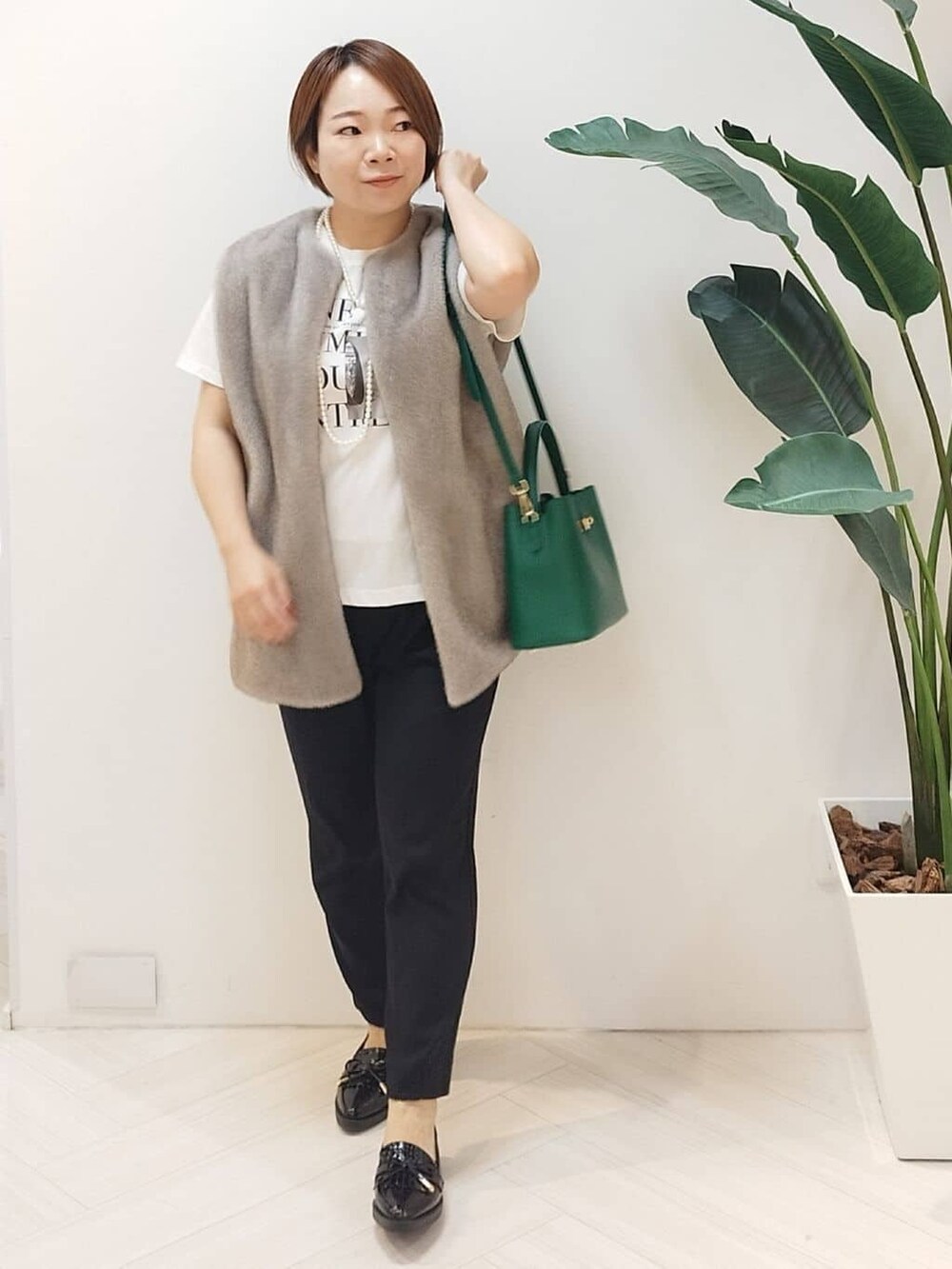 ベージュ系のベスト、ホワイト系のTシャツ/カットソー、ブラック系のその他パンツを着用したレディースの秋コーディネートの2枚目の写真