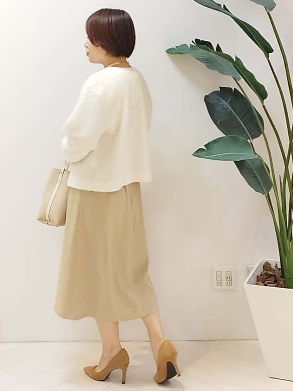 ホワイト系のカーディガン/ボレロ、ベージュ系のワンピース、ベージュ系のショルダーバッグを着用したレディースの秋コーディネートの7枚目の写真