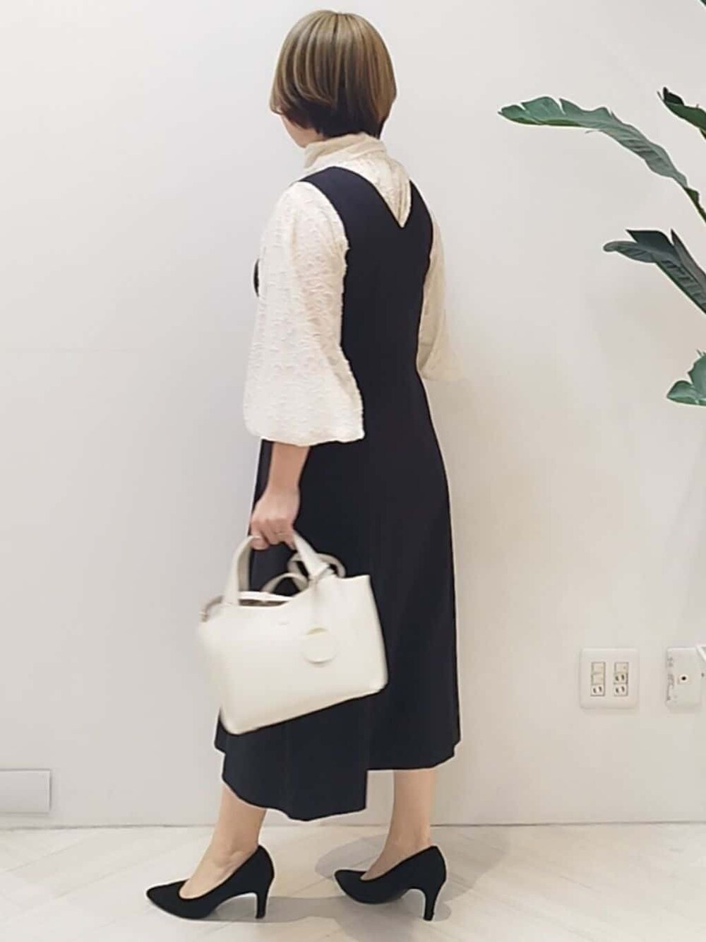 ブラック系のワンピース、ホワイト系のシャツ/ブラウス、ホワイト系のショルダーバッグを着用したレディースの冬コーディネートの5枚目の写真