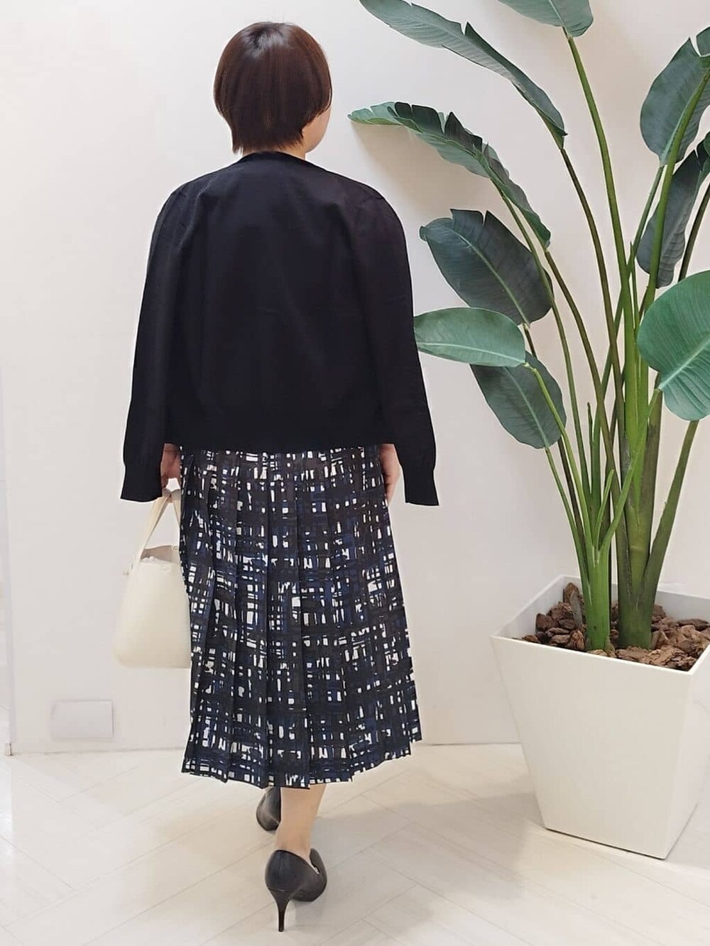 ブラック系のカーディガン/ボレロ、ブラック系のニット/セーター、ブルー系のスカートを着用したレディースの春コーディネートの8枚目の写真