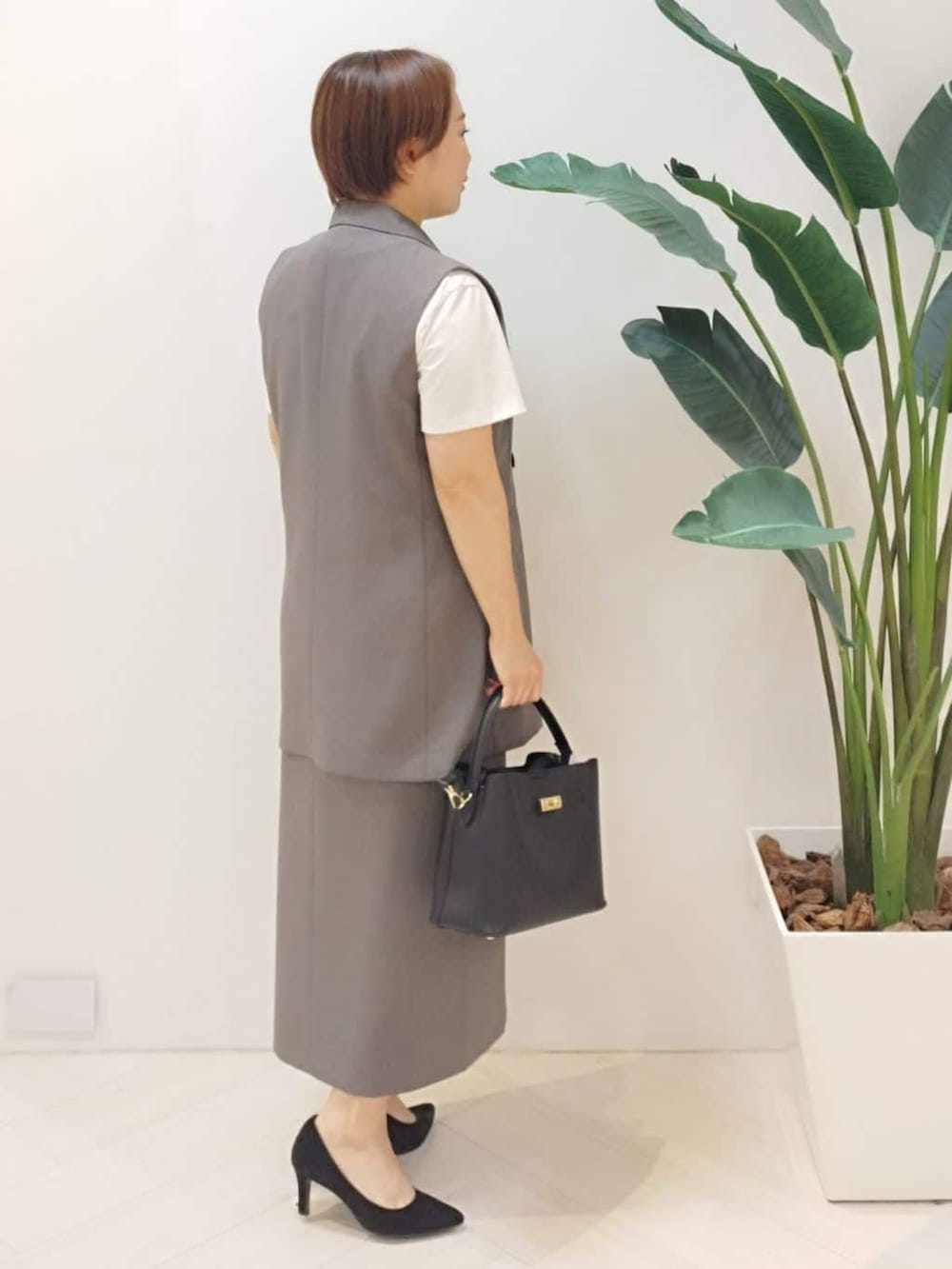 ブラウン系のベスト、ホワイト系のTシャツ/カットソー、ブラウン系のスカートを着用したレディースの秋コーディネートの8枚目の写真
