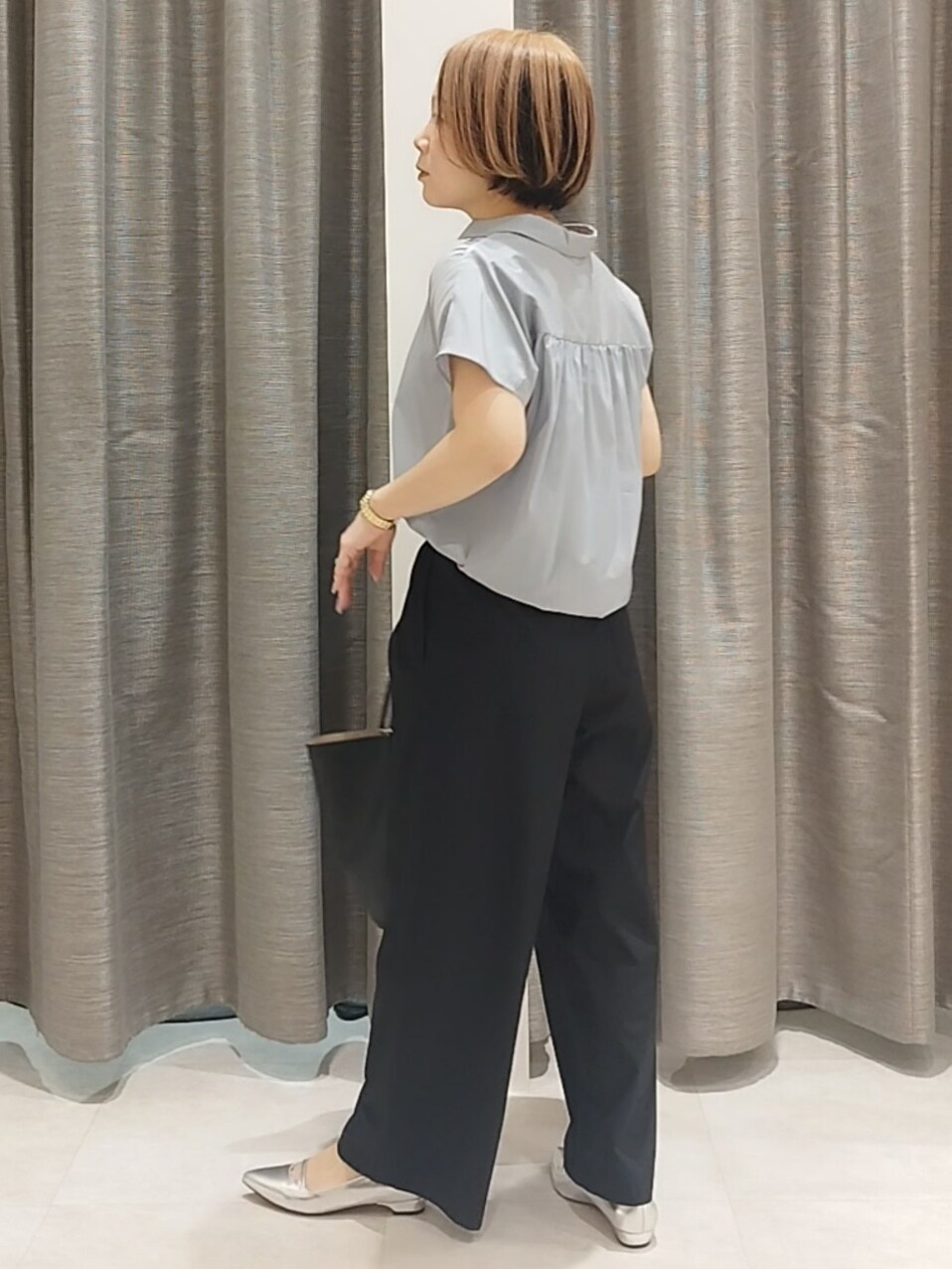 シルバー系のその他シューズ、ブルー系のシャツ/ブラウス、ブラック系のトートバッグを着用したレディースの春コーディネートの7枚目の写真
