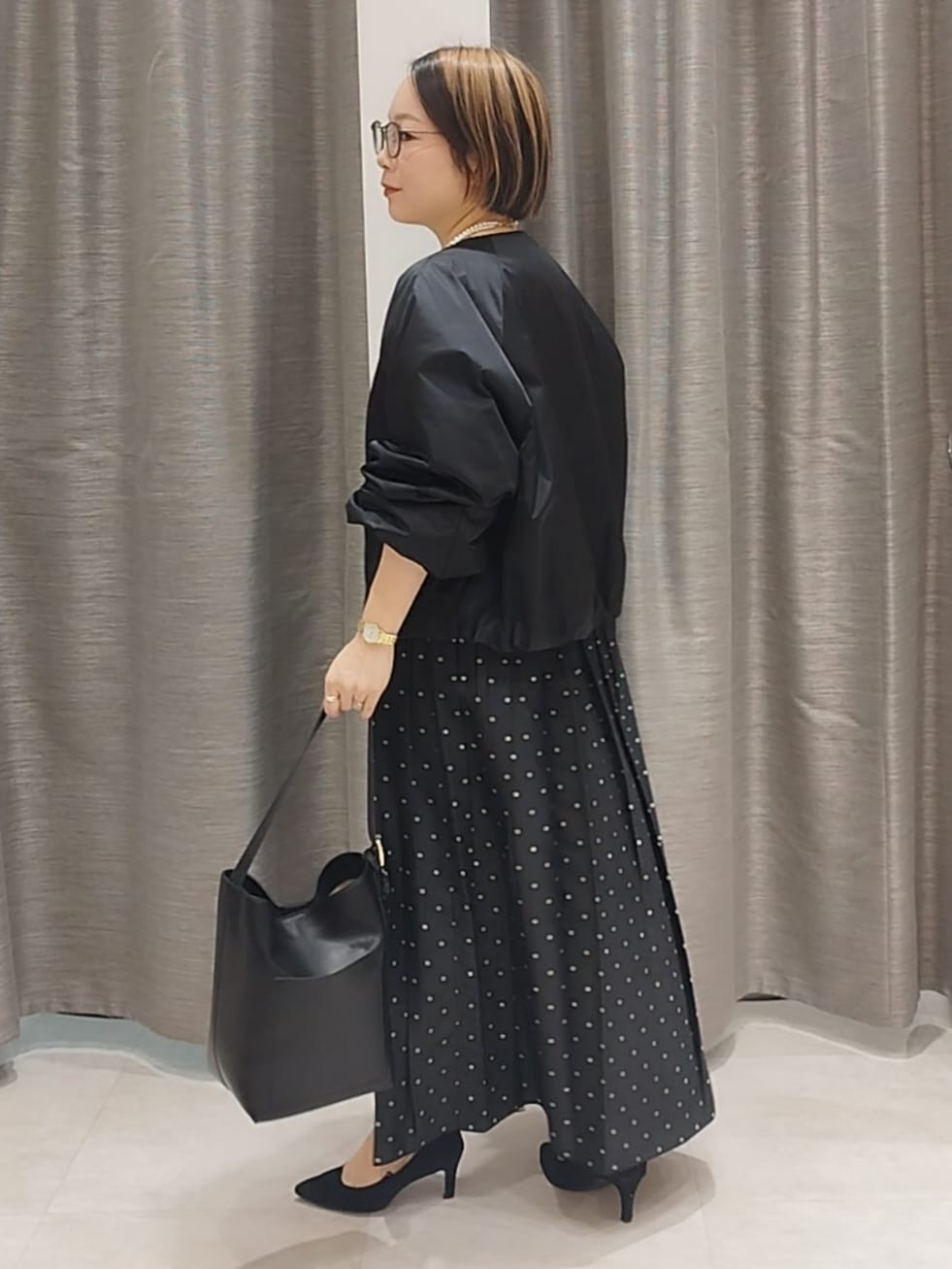 ホワイト系のTシャツ/カットソー、ブラック系のスカート、ブラック系のショルダーバッグを着用したレディースの秋コーディネートの4枚目の写真
