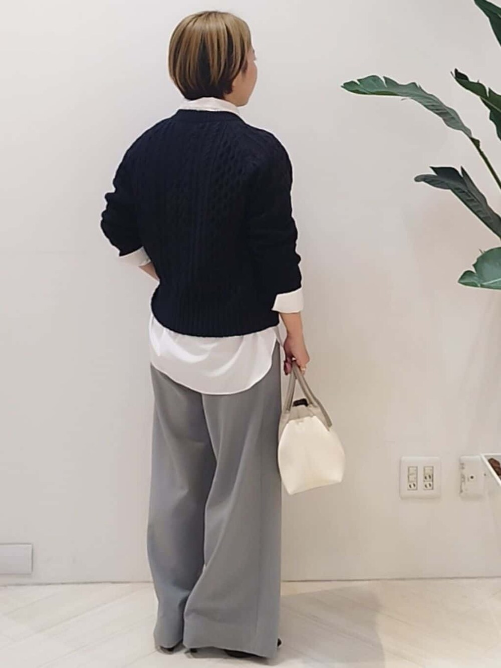 ブルー系のニット/セーター、ホワイト系のシャツ/ブラウス、グレー系のその他パンツを着用したレディースの冬コーディネートの6枚目の写真