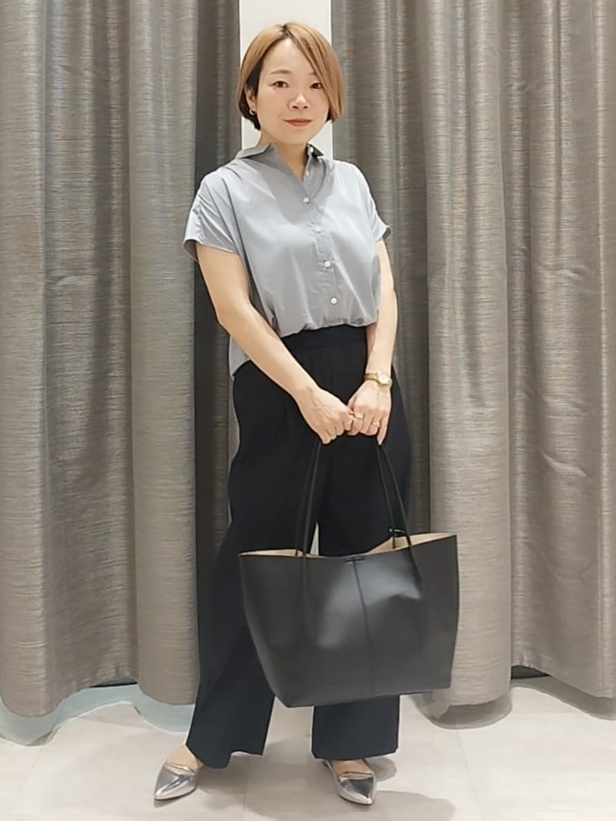シルバー系のその他シューズ、ブルー系のシャツ/ブラウス、ブラック系のトートバッグを着用したレディースの春コーディネートの3枚目の写真