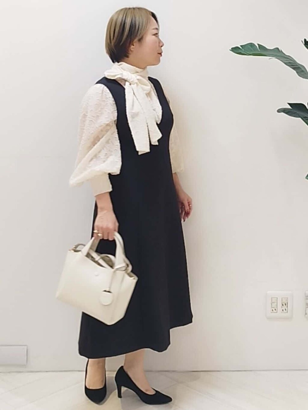 ブラック系のワンピース、ホワイト系のシャツ/ブラウス、ホワイト系のショルダーバッグを着用したレディースの冬コーディネートの6枚目の写真