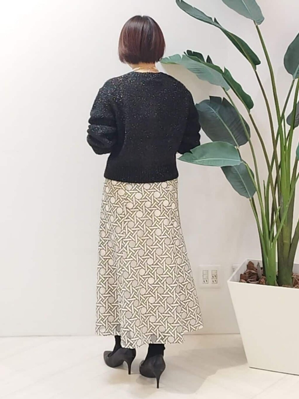 ブラック系のカーディガン/ボレロ、ホワイト系のスカートを着用したレディースの冬コーディネートの6枚目の写真